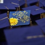 a sea of grad caps at Commencement; one reads "my dreams came true at UConn"
